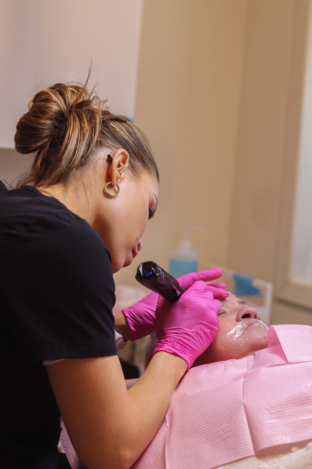 Jade performing microblading on a client in soft natural light